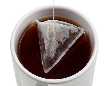 最顶端的茶叶泡在杯里袋紧闭着白色背景的孤立高清图片