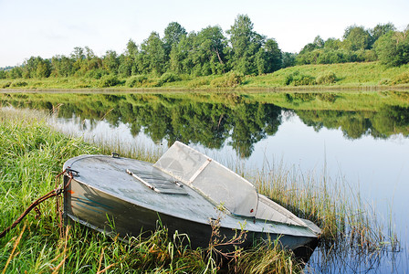 夏日小河绿岸上的旧船图片