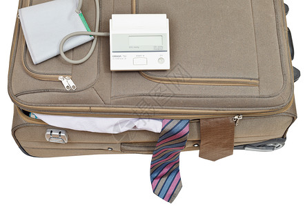 白色背景与男连接的手提箱上血压监视器与白色背景隔离图片