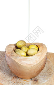 木碗里橄榄上薄流的油在白色背景上隔绝关闭图片