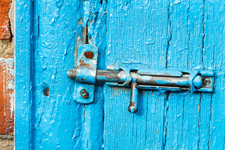 门闩破旧的蓝漆门紧关上背景