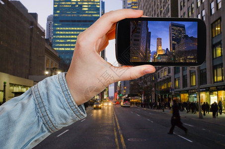 旅行概念以移动工具在晚上拍摄纽约市照片的游客图片