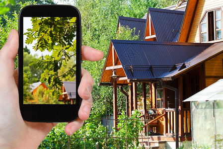 旅行概念游客在夏季用智能手机拍摄村庄房屋院子图片