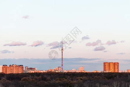 莫斯科粉红春夕阳的电视塔和城市住宅背景图片