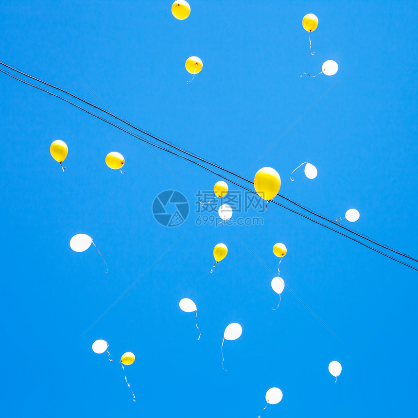 玩具气球在城市蓝色天空中漂浮图片