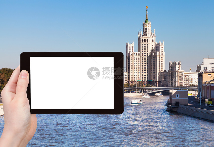 旅行概念手持平板电脑有剪出屏幕的平板电脑和莫斯科伏索特卡背景上的摩天大楼图片