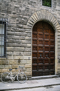 前往意大利冬季在佛罗伦萨市街上中世纪住宅门附近的自行车图片