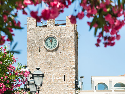 娜奥米沃茨前往西西里岛意大利观看中世纪钟楼托雷戴尔奥罗罗吉奥在广场九阿普里勒在陶尔米纳市在夏天背景