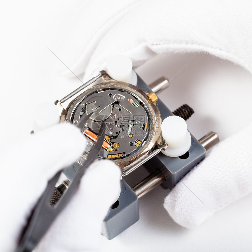 Watchmaker车间用石英手表替换电池由白色背景的tweezers关闭图片