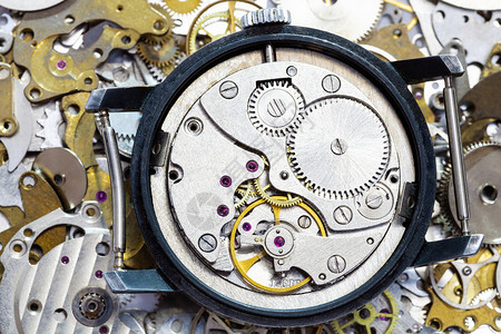 手表制作车间在时钟备件堆上打开老式机械手表图片