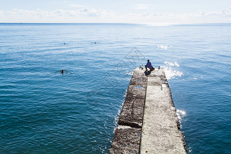 前往克里米亚上午在阿拉什塔市黑海岸堤码头捕鱼的渔民高清图片