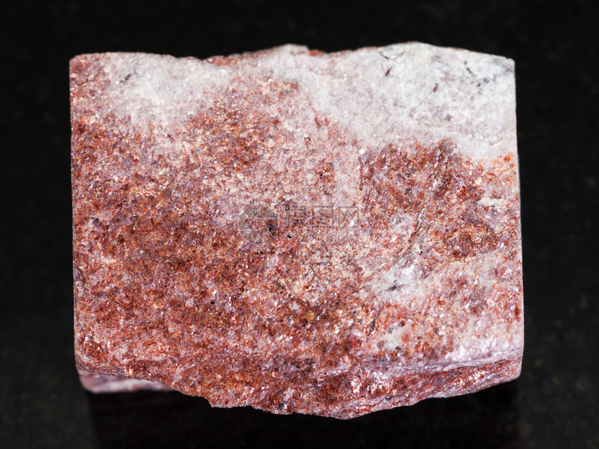 俄罗斯乌拉尔山脉维德洛夫克地区VerkhneyeDubrovo区黑暗花岗岩背景的粗粉红色Aventurine石图片