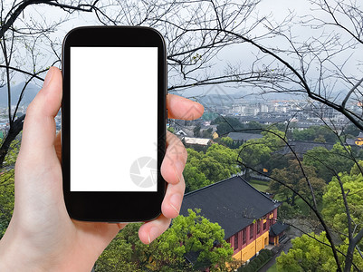 旅游概念春绿色城市公园和吉林的智能手机旅游照片并切断广告标志屏幕图片