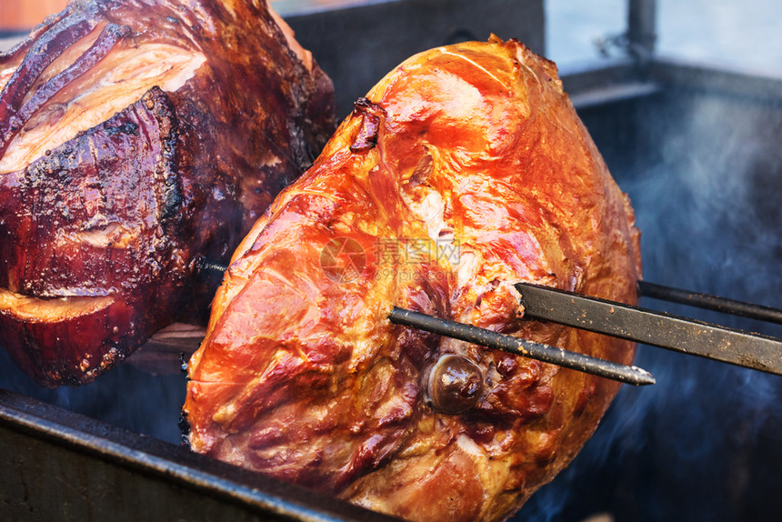 美味的猪肉火腿在露天炉上煮熟街的食物图片