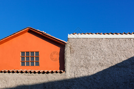 天空背景上的橙色房子窗口和墙背景