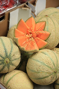 市场中新鲜的橘子甘塔罗普甜瓜图片