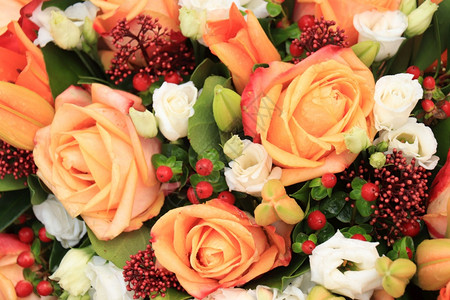 橙色玫瑰红浆果和山羊花在一个大的结婚中心高清图片