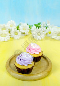 黄木板和蓝背景上盘子涂着奶油的美味蛋糕奶油的美味蛋糕图片