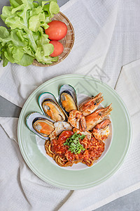 绿唇贻贝盘上番茄酱的意大利面和海鲜酱的意大利面和海鲜酱的意大利面和背景