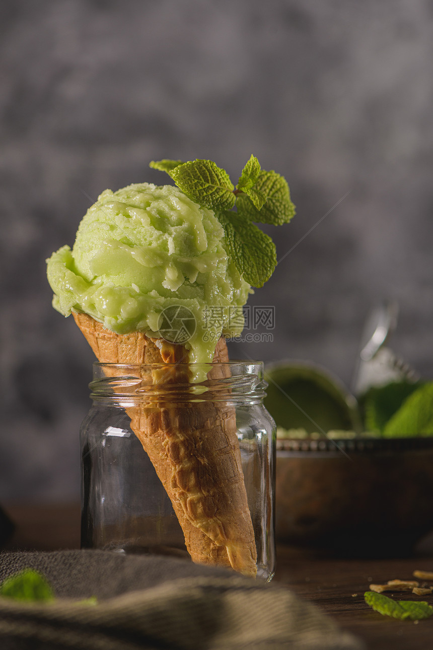 Pistchio冰淇淋在一个黑暗的生锈碗和华夫饼锥在棕色木质背景图片