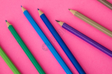 散布在粉红色背景的彩铅笔团背景图片