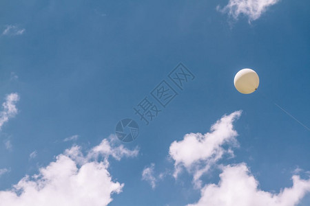 白色气球在蓝色天空中飞翔背景图片