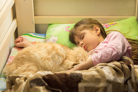 小女孩和毛猫睡在床上图片