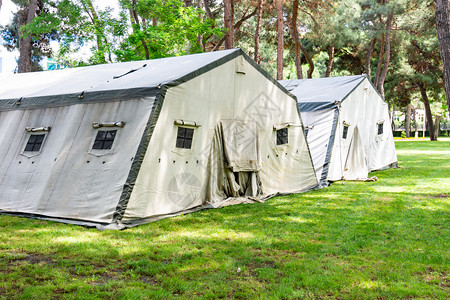 指示性概念图紧急情况部在森林种植园草坪上铺设的大帐篷背景
