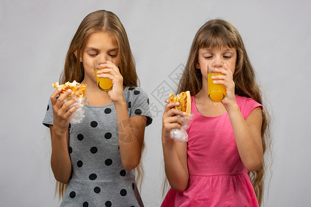 两个女孩喝果汁吃包已清洗高清图片素材