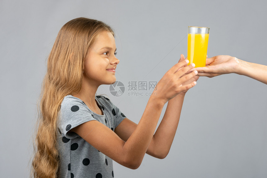 女孩用两只手从另一个人中拿杯果汁图片