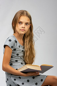 一个10岁的女孩分心从看书框架图片