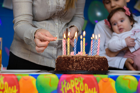 点蜡烛孩子妈在生日派对上蛋糕点蜡烛背景