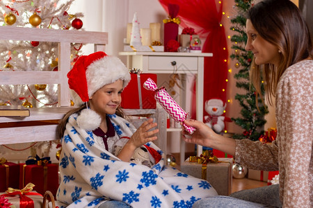 女孩给一个子大糖果在圣诞节房间的孩子图片