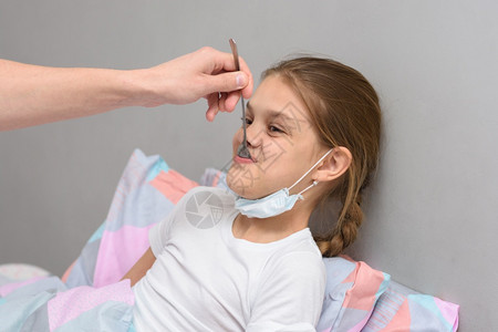 生病的女孩用嘴里勺子给一个女孩吃药图片