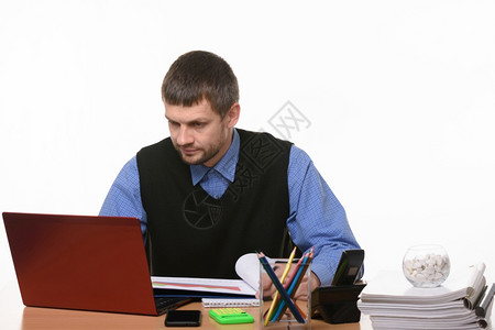 男人看笔记本电脑的显示器坐在桌子上图片