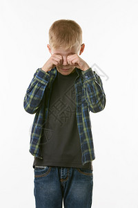 哭泣的男孩用拳头摸他的眼睛图片