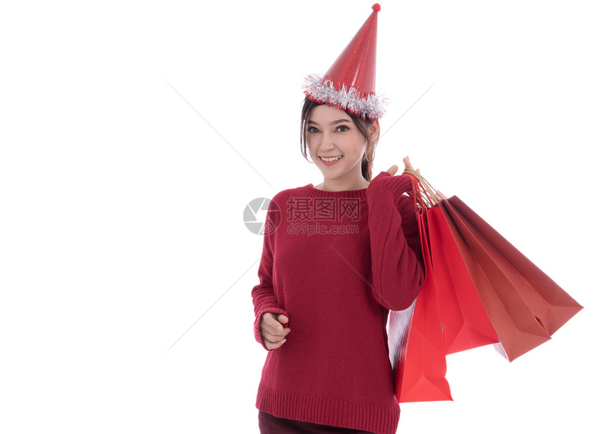 怀着白背景孤立的购物袋快乐年轻女子圣诞节概念图片