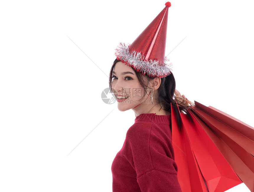 怀着白背景孤立的购物袋快乐年轻女子圣诞节概念图片