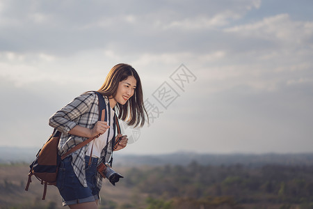 农村携带背和照相机的女游客背景图片