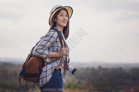 农村携带背和照相机的女游客旅游业高清图片素材