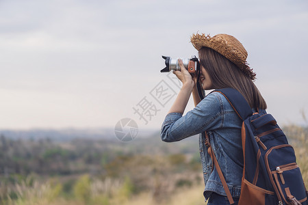 旅游女客用摄像头拍照片山高清图片素材