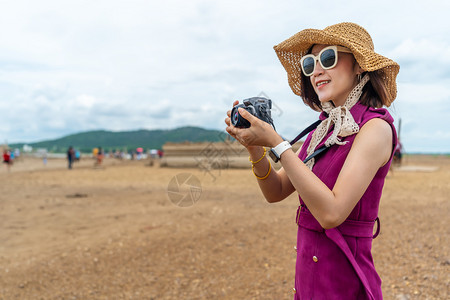 旅行妇女在农村拍摄带有相机的片草地高清图片素材