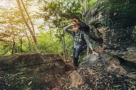 累的徒步妇女爬上森林图片