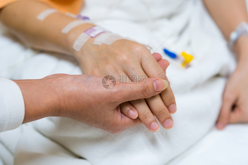 医院里有人用手握着病的放在床上图片