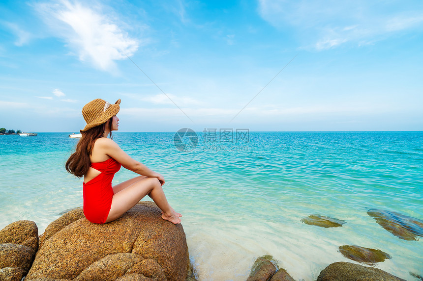 身穿泳装的年轻女子坐在泰国拉永高文诺克岛海滨石滩上图片