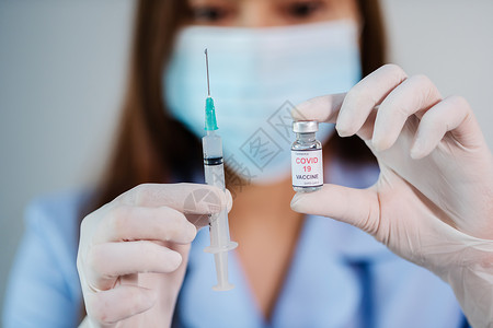 持有科罗纳新冠疫苗瓶和注射器药物的女医生图片