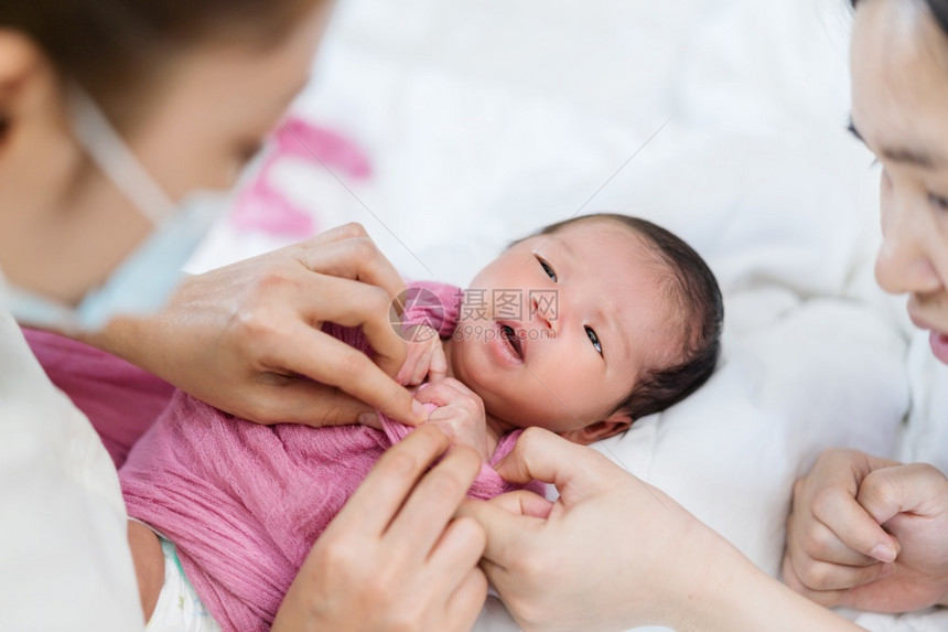 母亲用毛毯包着婴儿新生图片