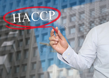 haccp年轻商人的手在摩天大楼背景应用概念上写了HACCP一词以促进业务或工作介绍背景