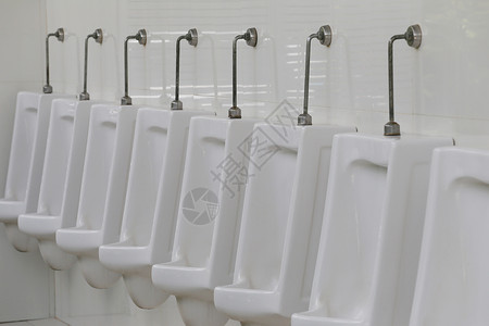 现代男厕所小便池白色陶瓷小便池男在厕所房间尿的高清图片素材