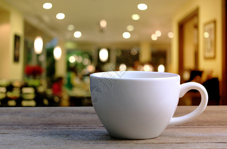 咖啡店木制桌上的白咖啡杯背景图片